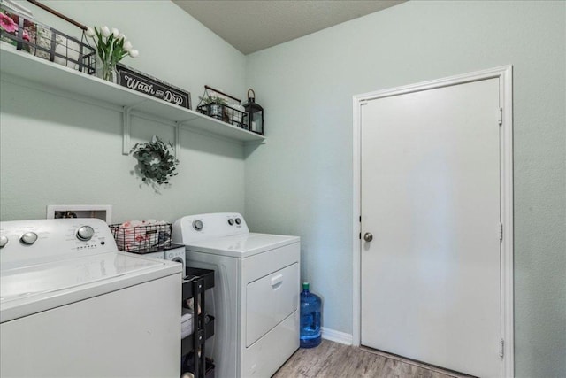laundry area featuring separate washer and dryer, light wood-style flooring, and laundry area