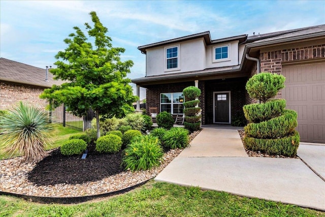 entrance to property featuring brick siding, stucco siding, fence, and a porch