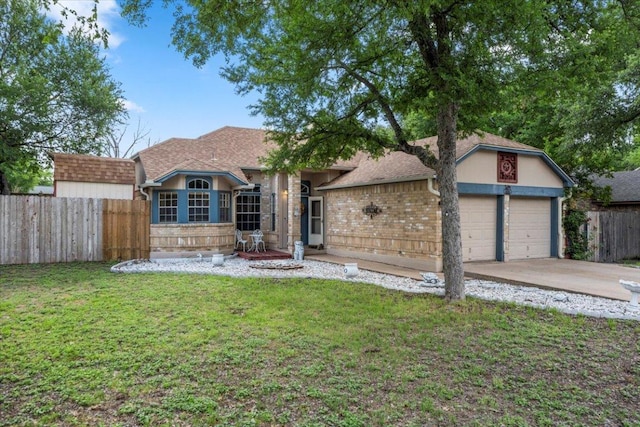 view of front facade with fence, concrete driveway, brick siding, and a front lawn