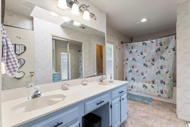 full bath with wallpapered walls, shower / bath combo with shower curtain, and a sink