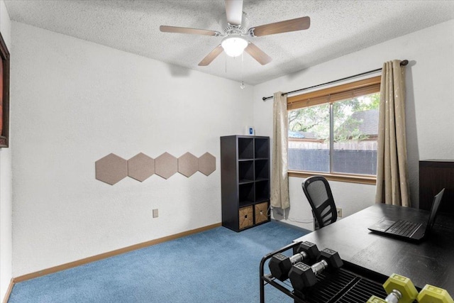 office space with a textured ceiling, carpet flooring, a textured wall, baseboards, and a ceiling fan