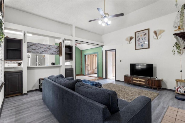 living area featuring baseboards, wood finished floors, and ceiling fan