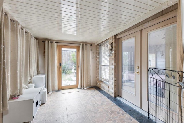 unfurnished sunroom with stone finish floor and wood ceiling