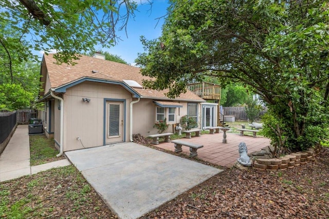 back of property with a patio, a chimney, a fenced backyard, and a shingled roof