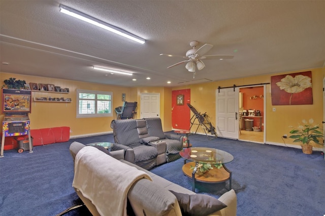 living room featuring a barn door, a ceiling fan, carpet flooring, and baseboards