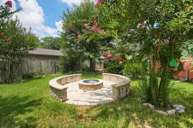 view of yard featuring fence private yard, a fire pit, and a patio area