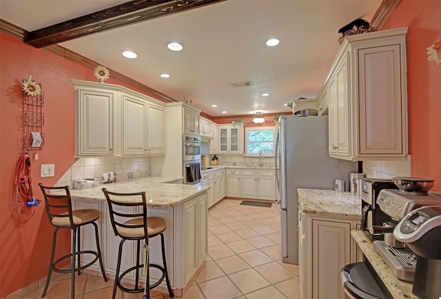 kitchen with a kitchen breakfast bar, light tile patterned floors, tasteful backsplash, visible vents, and a peninsula