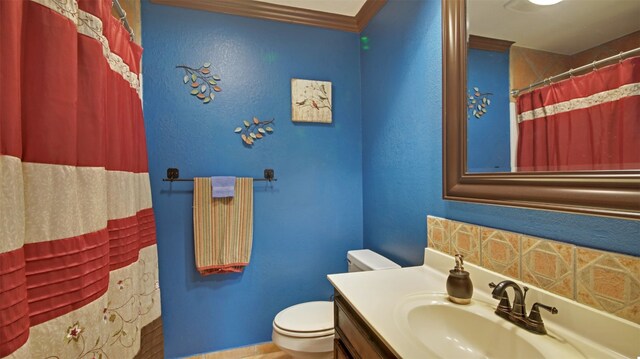 bathroom featuring vanity, curtained shower, toilet, baseboards, and ornamental molding