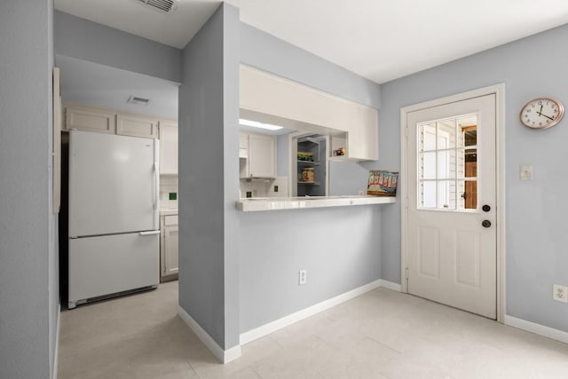 1904 Goodrich Ave Unit 16, Austin, TX 78704 - kitchen with freestanding refrigerator, baseboards, cream cabinetry, and tile counters