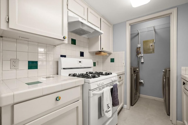 1904 Goodrich Ave Unit 16, Austin, TX 78704 - kitchen with white gas stove, under cabinet range hood, tile countertops, white cabinets, and washer and dryer