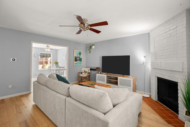 1904 Goodrich Ave Unit 16, Austin, TX 78704 - living room featuring ceiling fan, light wood-style flooring, a brick fireplace, and baseboards