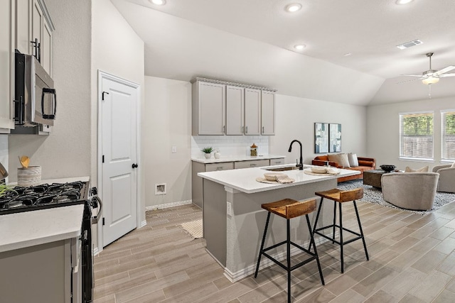 135 Hackberry Ln, Bastrop, TX 78602 - kitchen with stainless steel microwave, black range with gas stovetop, gray cabinets, a sink, and recessed lighting