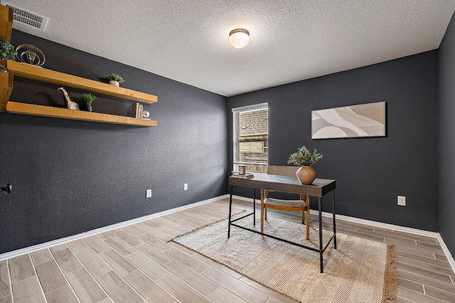 135 Hackberry Ln, Bastrop, TX 78602 - office featuring baseboards, visible vents, wood finished floors, and a textured ceiling