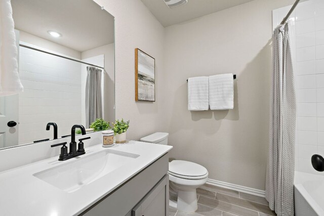 135 Hackberry Ln, Bastrop, TX 78602 - bathroom featuring vanity, toilet, baseboards, shower / bathtub combination with curtain, and wood finish floors