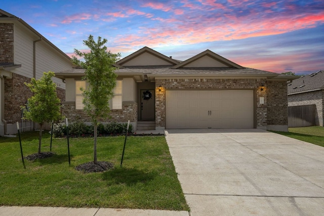 135 Hackberry Ln, Bastrop, TX 78602 - ranch-style home with driveway, a yard, a garage, and brick siding