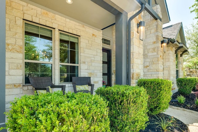 2724 Rain Song Dr, Leander, TX 78641 - view of exterior entry featuring stone siding, a porch, and roof with shingles