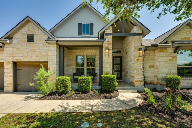 2724 Rain Song Dr, Leander, TX 78641 - view of front of property with a porch, stone siding, a garage, a metal roof, and driveway