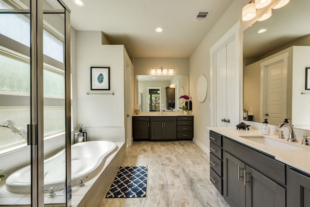 2724 Rain Song Dr, Leander, TX 78641 - bathroom with two vanities, a bath, and recessed lighting