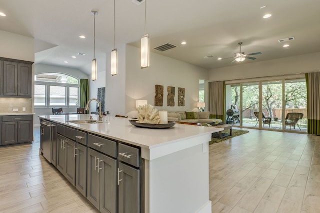 2724 Rain Song Dr, Leander, TX 78641 - kitchen featuring ceiling fan, open floor plan, light wood-style floors, light countertops, and a kitchen island with sink