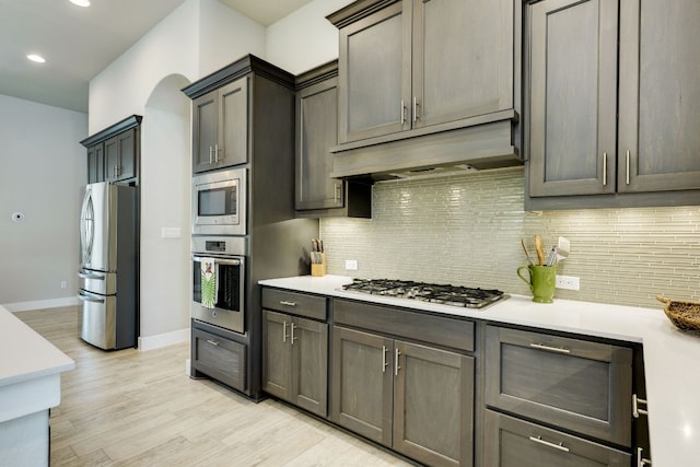 2724 Rain Song Dr, Leander, TX 78641 - kitchen with appliances with stainless steel finishes, light countertops, backsplash, light wood finished floors, and recessed lighting