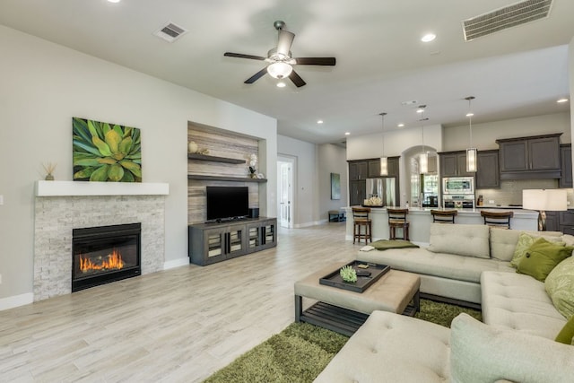 2724 Rain Song Dr, Leander, TX 78641 - living area featuring a ceiling fan, light wood-style floors, recessed lighting, and a stone fireplace