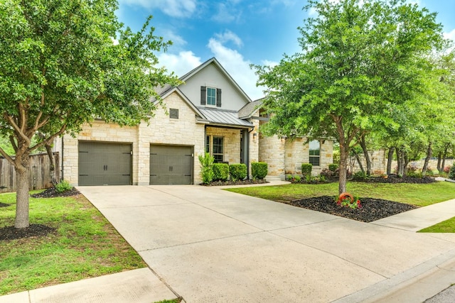 2724 Rain Song Dr, Leander, TX 78641 - view of front facade featuring stone siding, a standing seam roof, driveway, a garage, and a metal roof