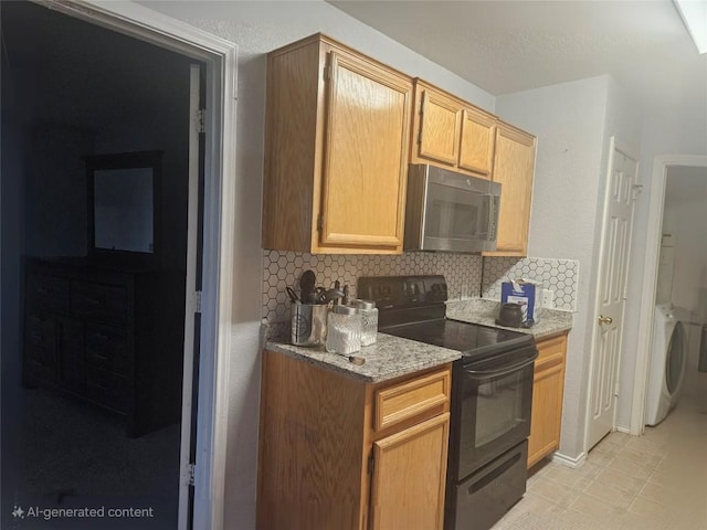 kitchen with stainless steel microwave, decorative backsplash, electric range, light stone countertops, and washer / dryer