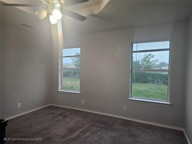 empty room featuring baseboards, dark carpet, and a ceiling fan