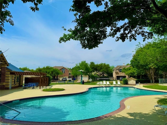 community pool with fence and a patio area