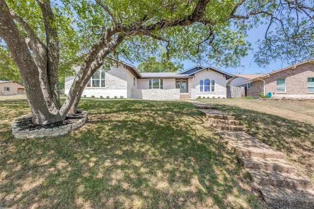 ranch-style house with a front lawn and brick siding