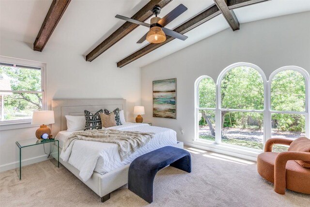 bedroom with carpet floors, vaulted ceiling with beams, and multiple windows