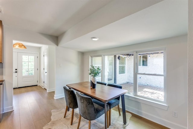 dining space with light wood-type flooring and baseboards