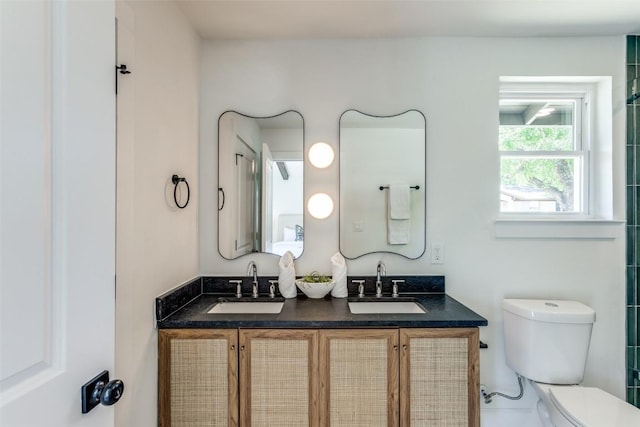full bathroom with double vanity, toilet, and a sink