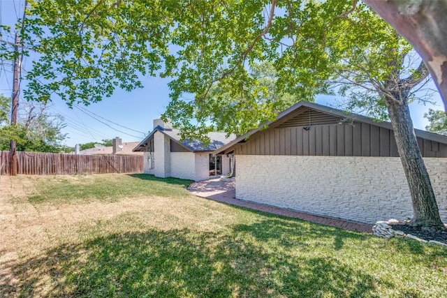 back of house featuring a lawn and fence