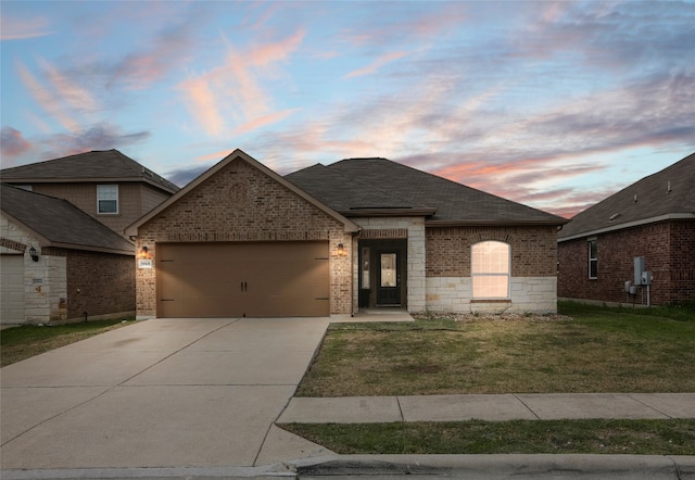 view of front of property with brick siding, a garage, roof with shingles, a front lawn, and concrete driveway