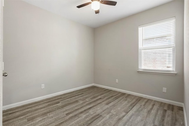 spare room with ceiling fan, wood finished floors, and baseboards