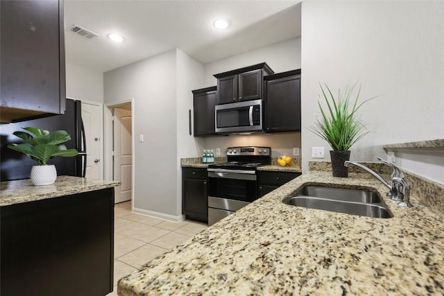 kitchen with light stone counters, light tile patterned floors, a sink, visible vents, and stainless steel appliances