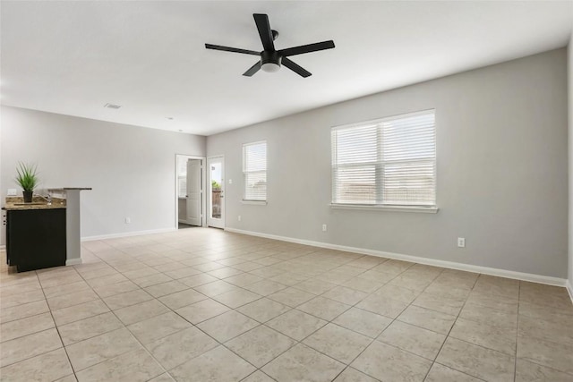 spare room with baseboards, visible vents, light tile patterned floors, and a ceiling fan