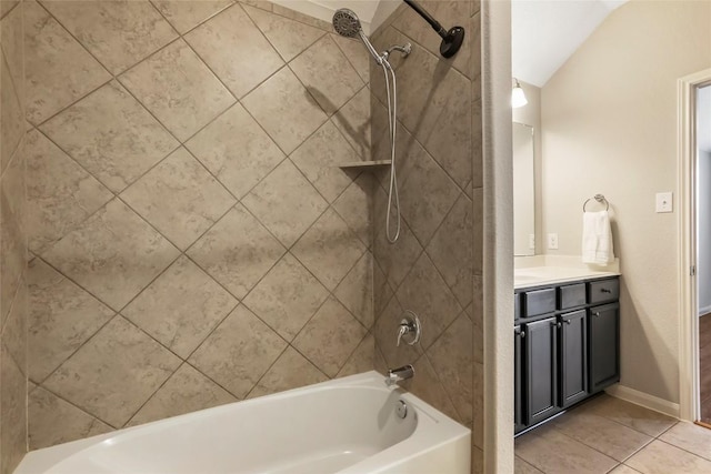 bathroom with bathtub / shower combination, tile patterned flooring, vaulted ceiling, and vanity