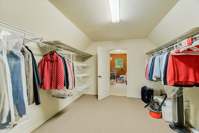 walk in closet featuring lofted ceiling and carpet floors
