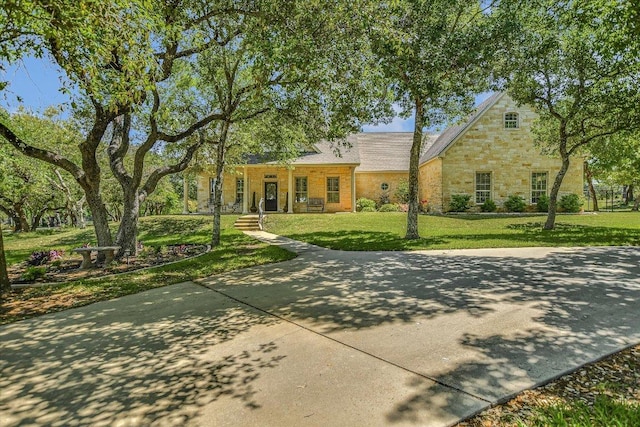 ranch-style house featuring a front lawn and stone siding