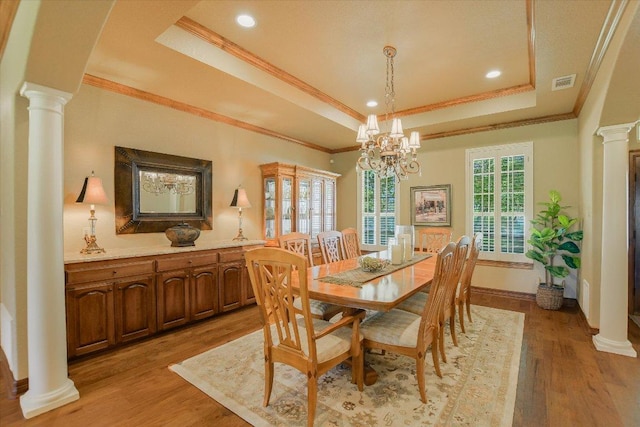 dining area featuring visible vents, crown molding, a tray ceiling, and decorative columns