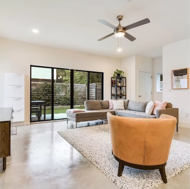living room with finished concrete flooring, a ceiling fan, and recessed lighting