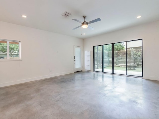 unfurnished room with baseboards, visible vents, a wealth of natural light, and finished concrete floors