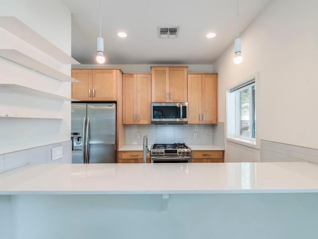 kitchen with visible vents, stainless steel appliances, a peninsula, and backsplash