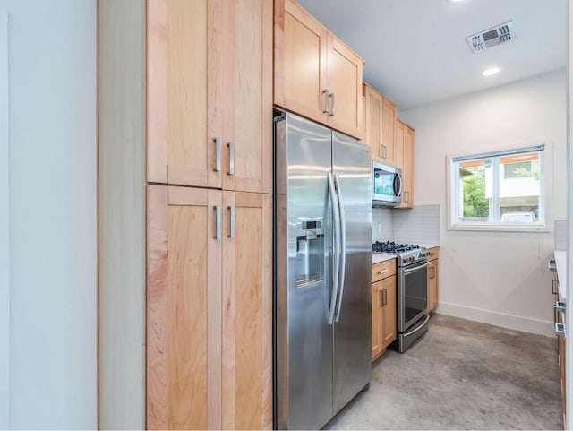 kitchen featuring visible vents, light brown cabinets, stainless steel appliances, baseboards, and concrete flooring