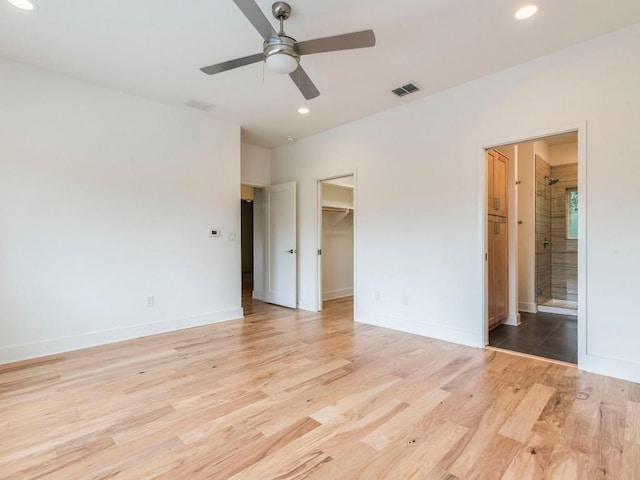 unfurnished bedroom with visible vents, light wood-type flooring, recessed lighting, and a spacious closet