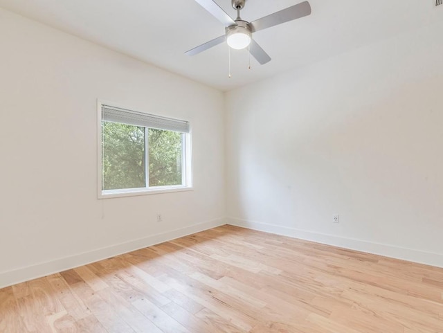 empty room with a ceiling fan, light wood finished floors, and baseboards