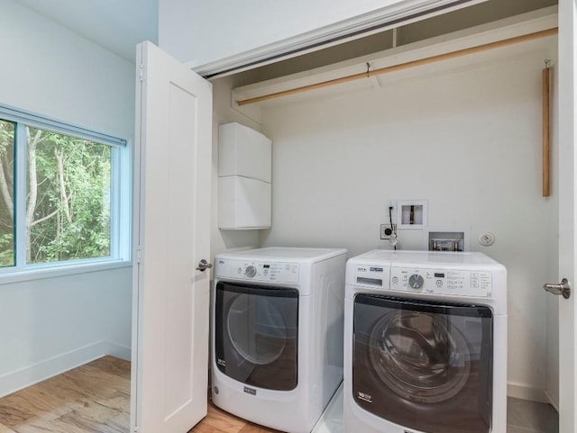 washroom with baseboards, laundry area, and washer and clothes dryer