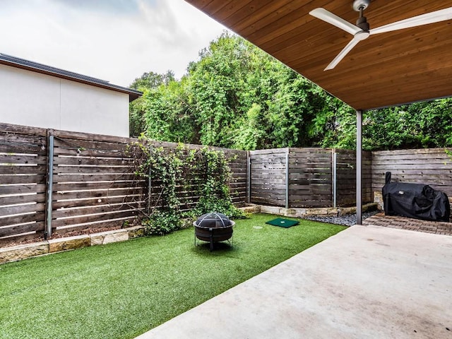 view of yard featuring a fire pit, a fenced backyard, a ceiling fan, and a patio area